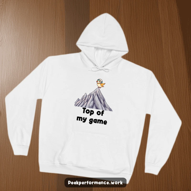Funny Hoodie: Tiny bird in a helmet soaring over a jagged summit, offering warm and humorous courage.